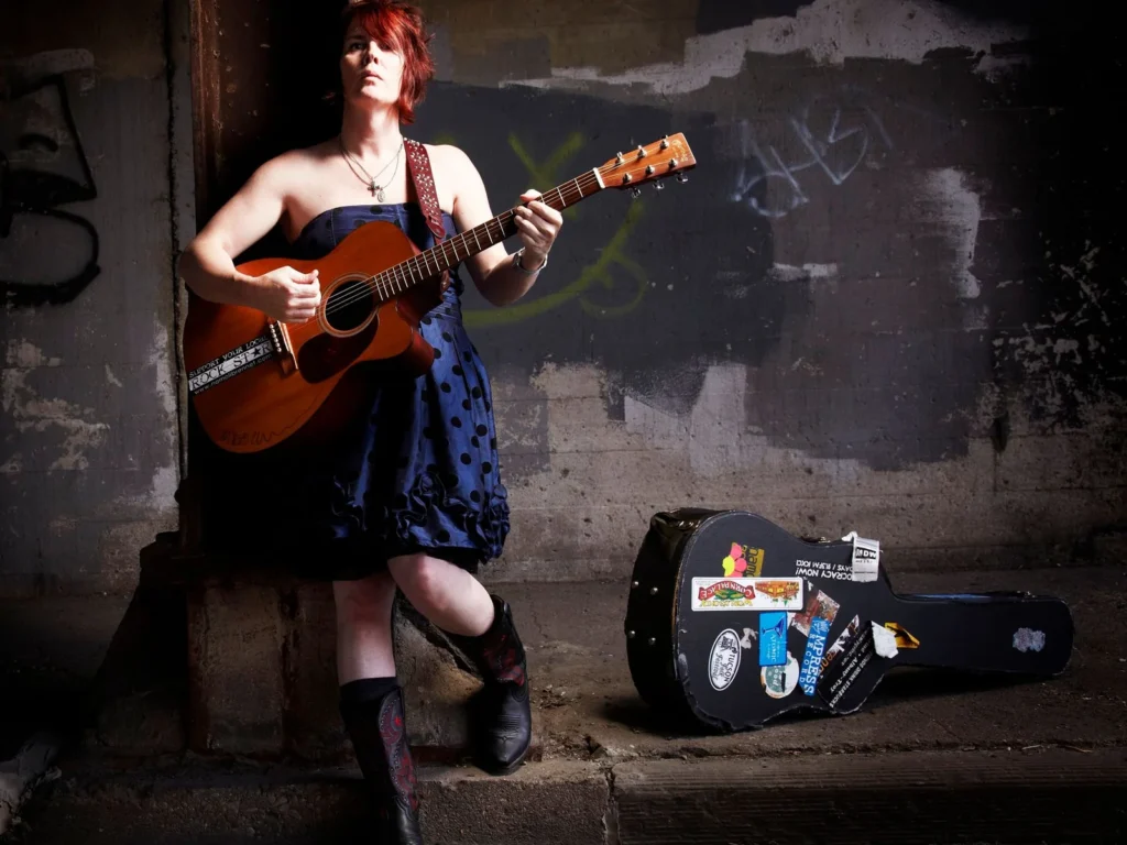 Singer-songwriter Namoli Brennet with an acoustic guitar
